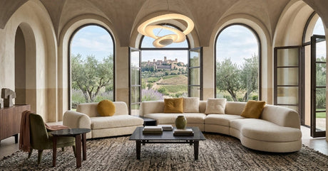 Italian curved sectional sofa with modern furniture in a bright, elegant interior.