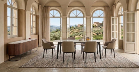Italian dining room with elegant table and chairs in a sunlit Tuscan-style interior.